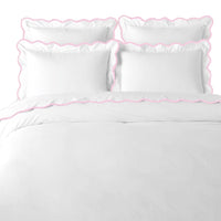The Scalloped Pink + White Duvet Cover by Laura Park Designs adds a charming touch to any girl's room.