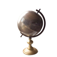 Decorative globe on a stand with a white background