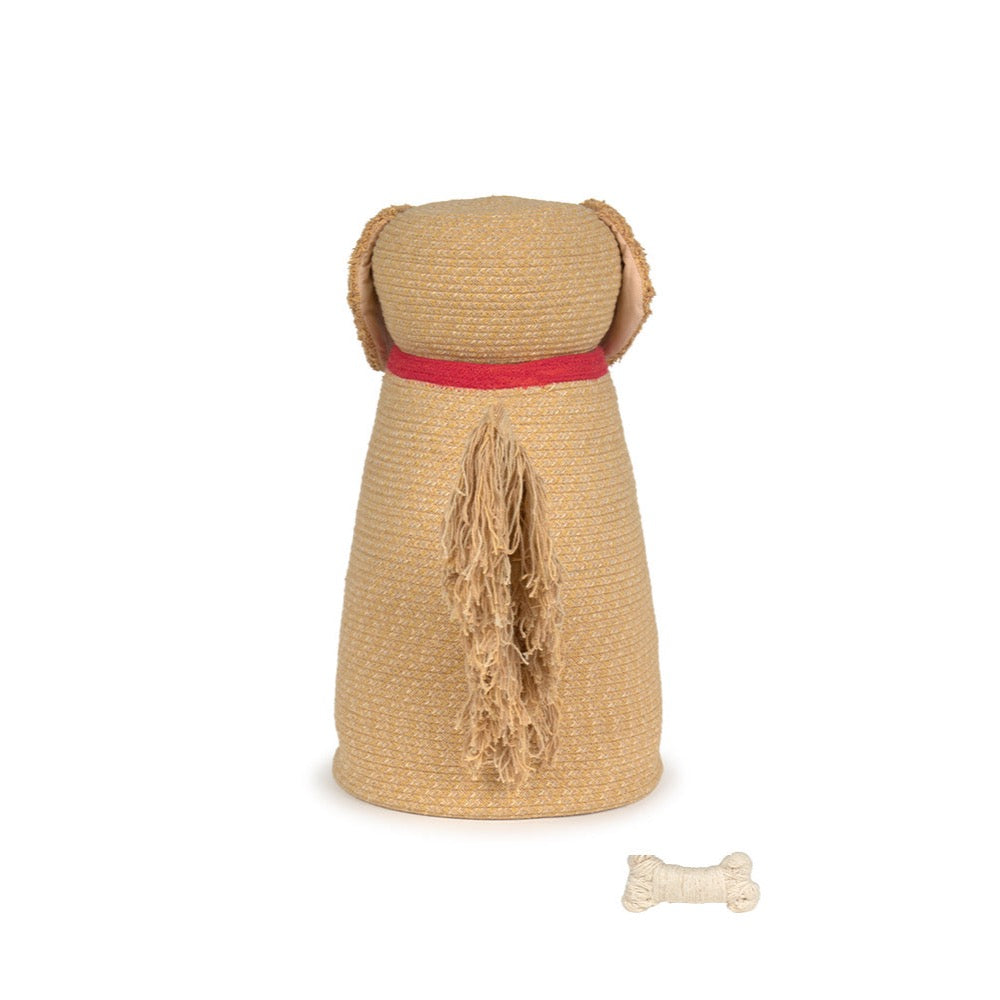 A woven straw dog-shaped basket in natural beige with a red collar detail, shown on a white background with a small bone-shaped accessory nearby.