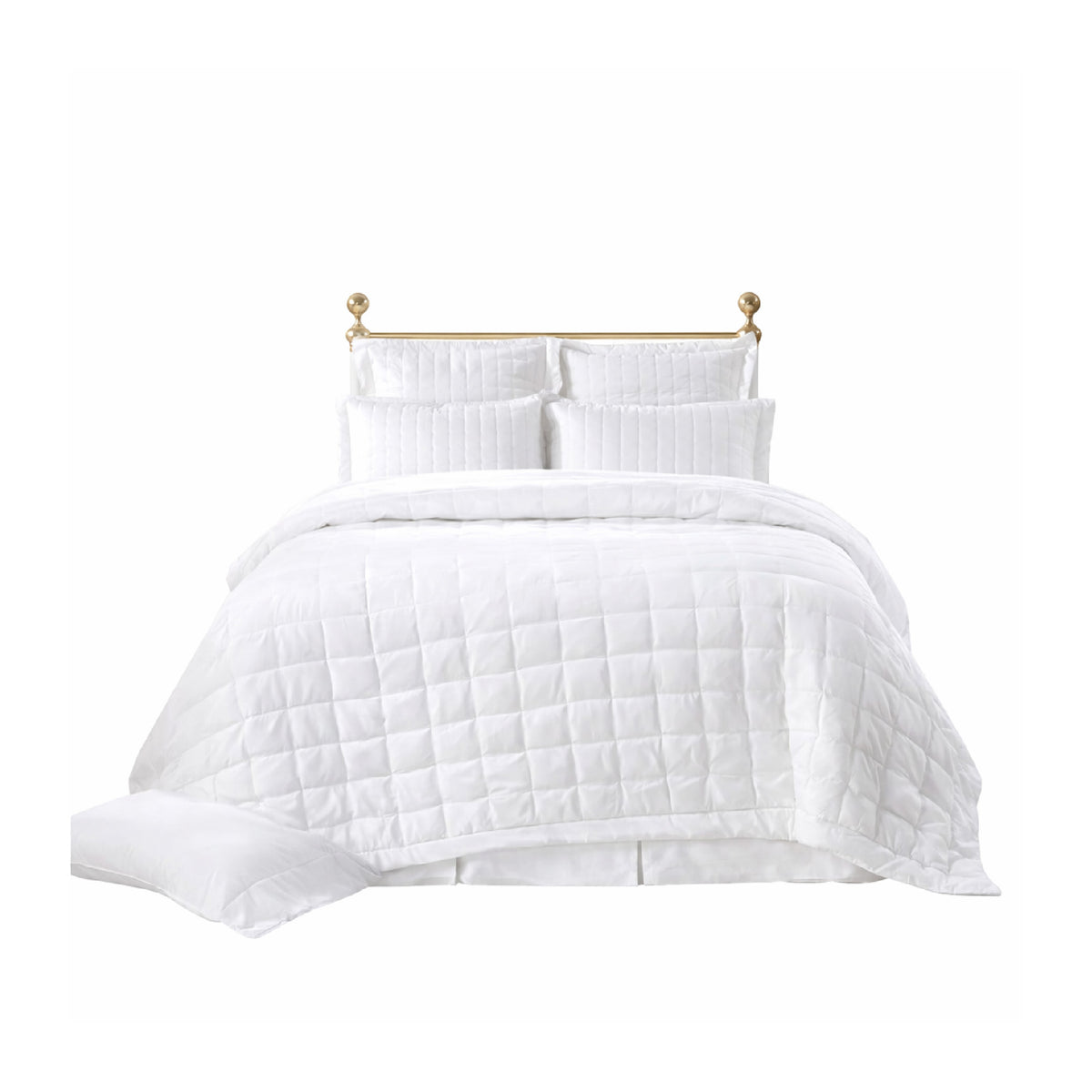 A neatly made bed with the Madison Pearl Bedding Collection by Orchids Lux Home and pearl shams against a gold headboard.