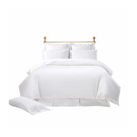 A neatly made bed with the Terrier Bedding Collection - Pearl by Orchids Lux Home, featuring a gold headboard.