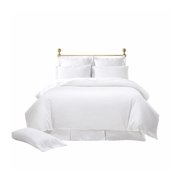 A neatly made bed with the Terrier Bedding Collection - Pearl by Orchids Lux Home, featuring a gold headboard.