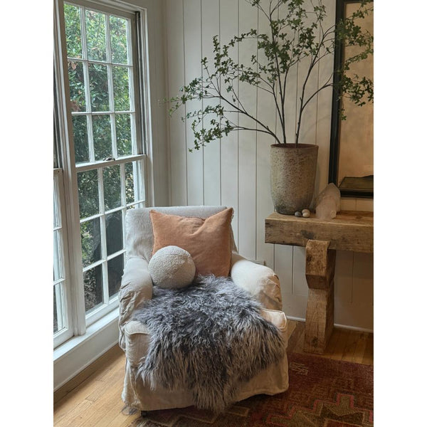lifetsyle image of 22"square blush velvet pillow with mini pom poms