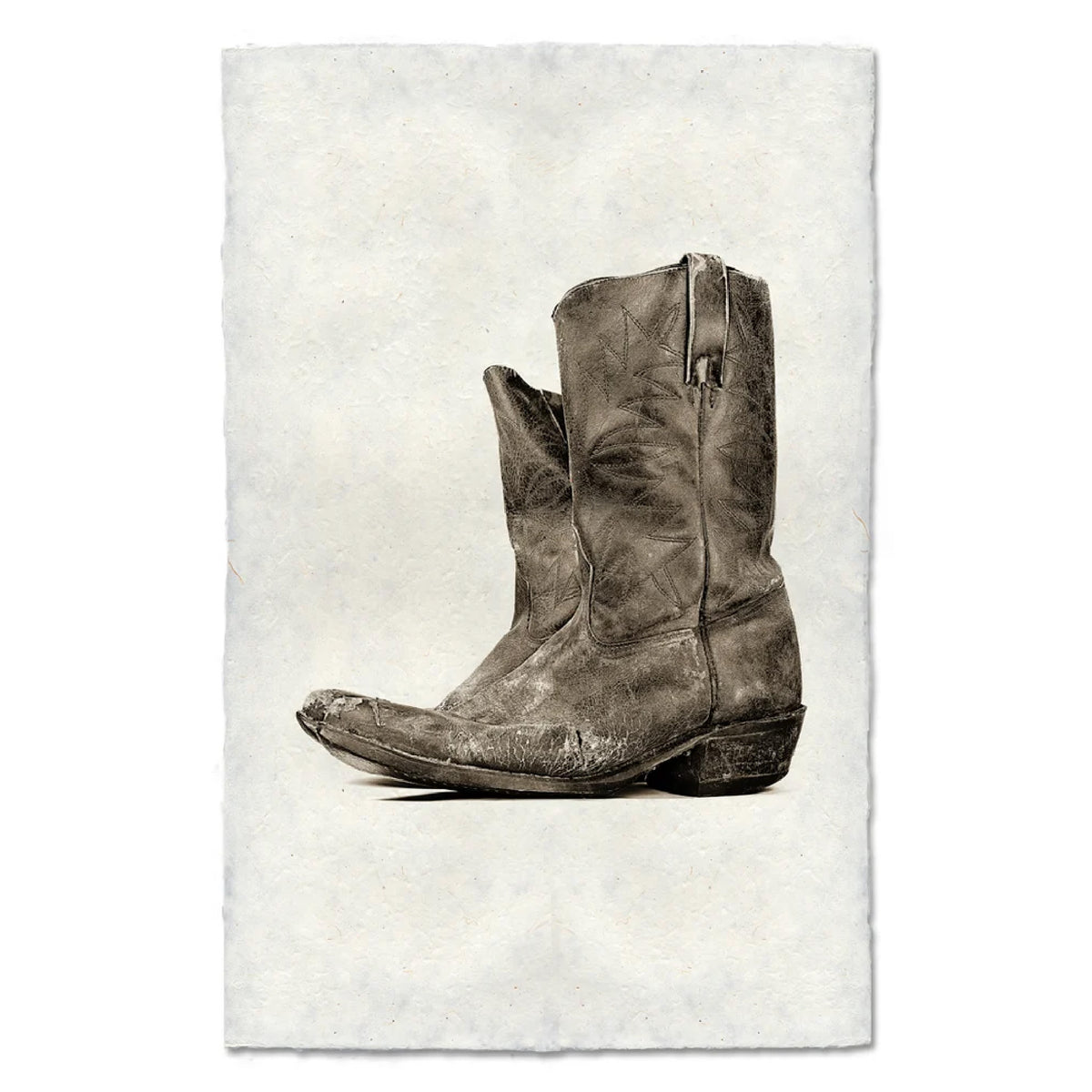 Brown leather boot on a textured off white background