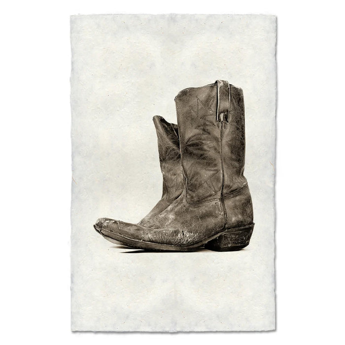 Brown leather boot on a textured off white background