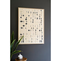 Kalalou's Framed Acrylic Abstract Stones Painting with black/beige circles on a dark wall, next to a plant & sculpture.