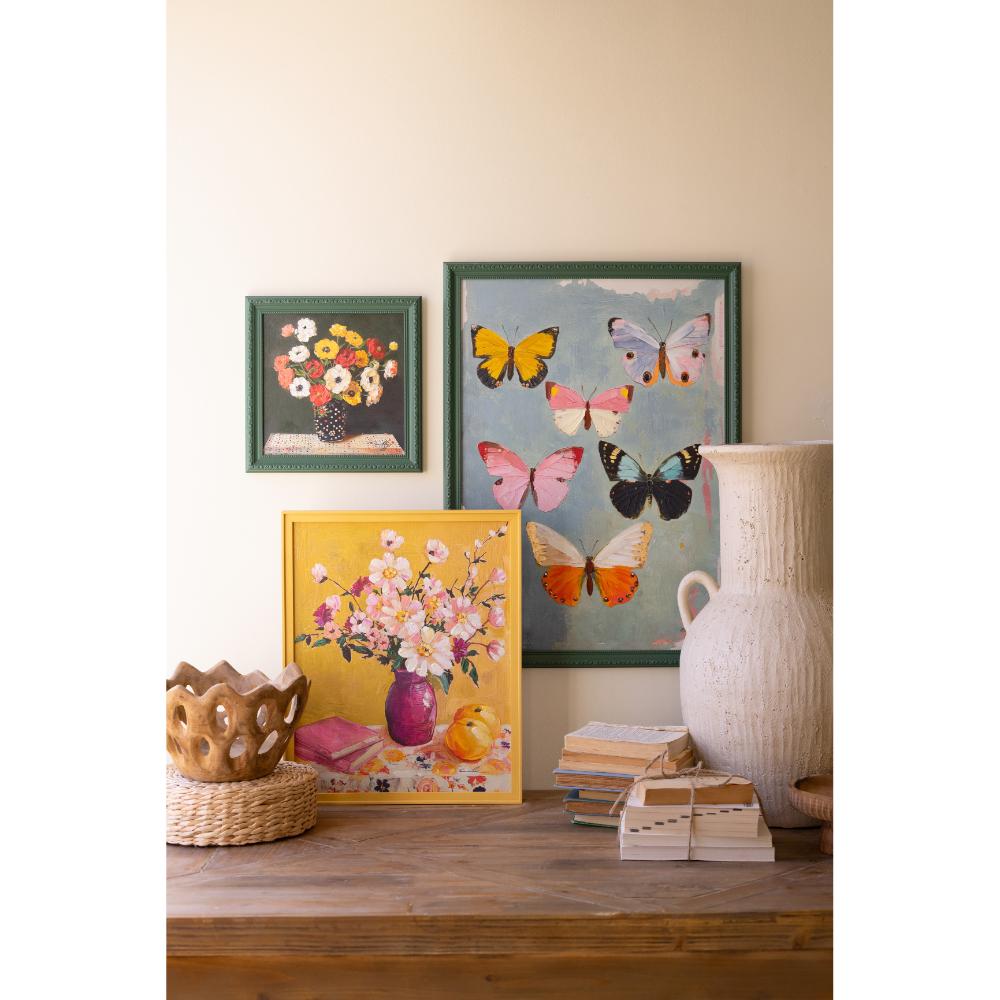 Decorative wall art with floral and butterfly designs on a wooden surface.
