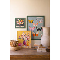 Decorative wall art with floral and butterfly designs on a wooden surface.