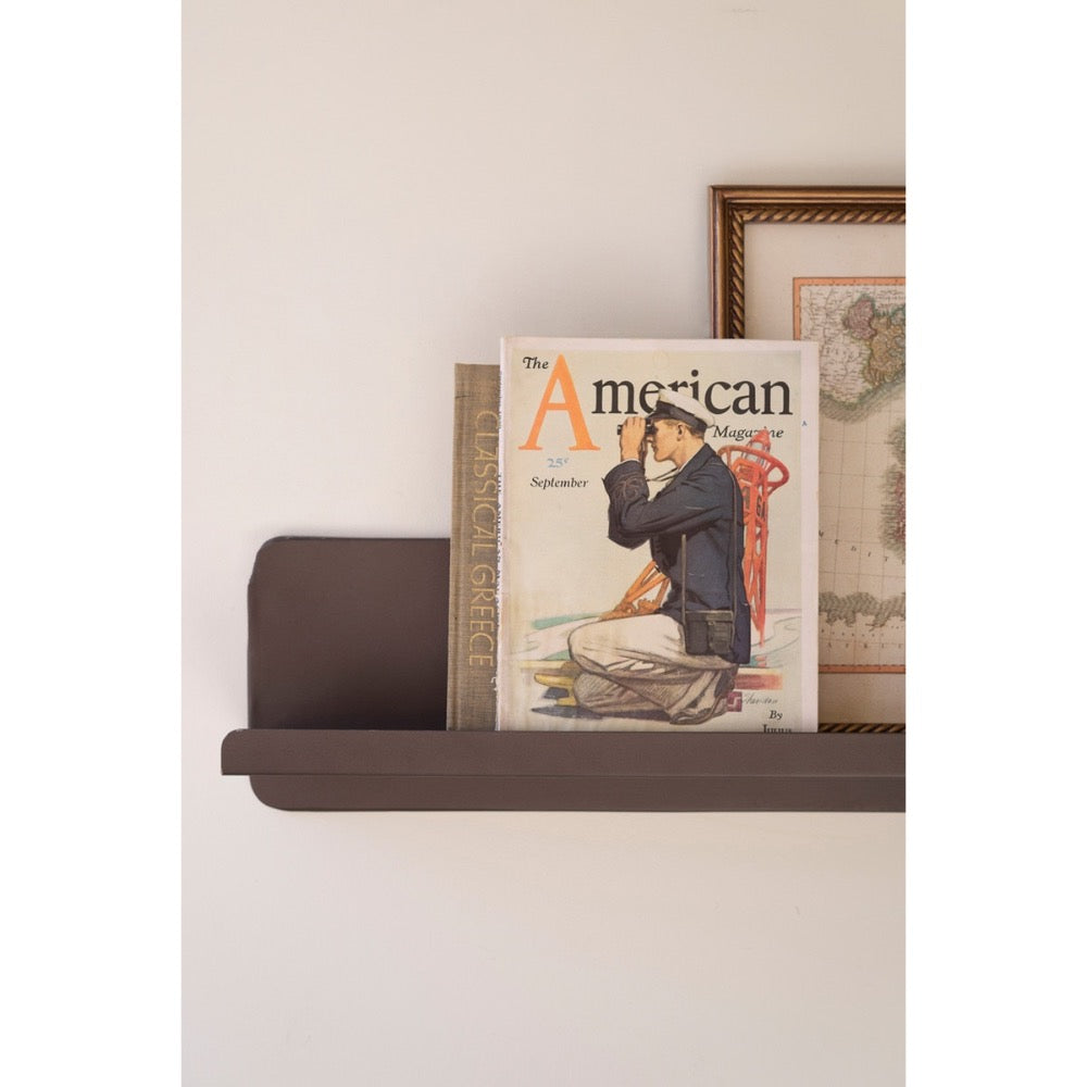 Magazine titled 'The American' on a shelf against a white wall