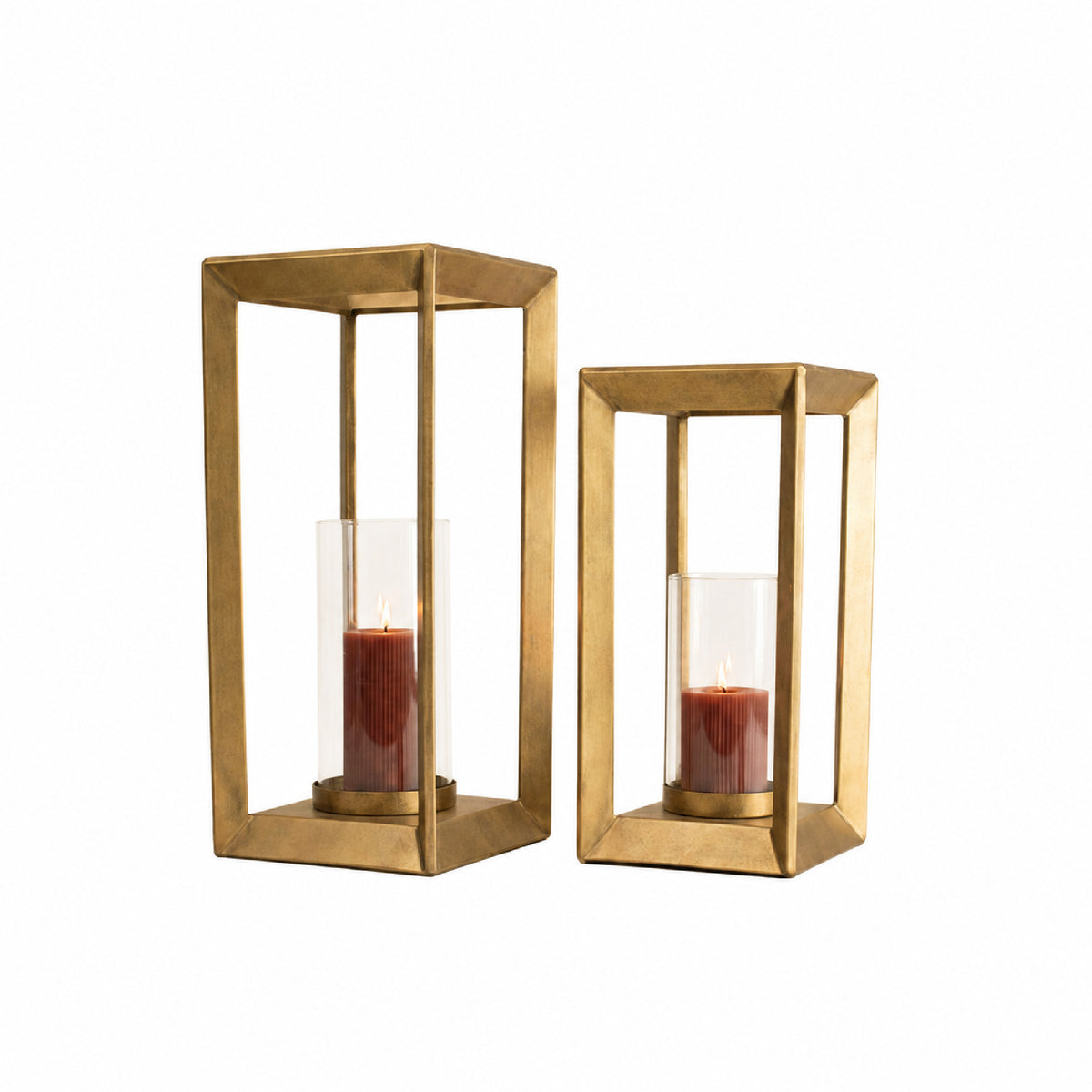 Two gold-toned metal lantern candle holders with clear glass cylinders and lit red candles, shown on a plain white background.
