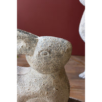 Kalalou Rustic Metal Rabbits, set of 2, ideal for garden decor against a dark red background.