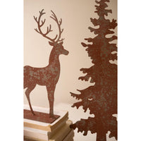 Close up if color metal sculptured tree and deer on books