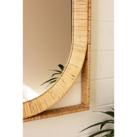 Round mirror with a rattan frame on a white wall