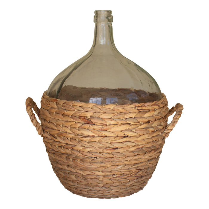 Glass demijohn in a woven basket on a white background