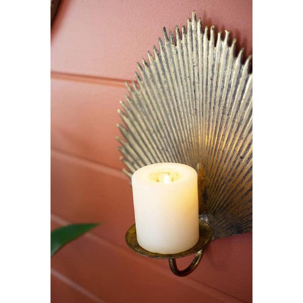 Decorative wall sconce with a candle on a pink wall