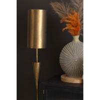 Gold floor lamp against a dark wall with decorative elements.