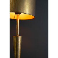 Gold floor lamp with a dark shade against a black background