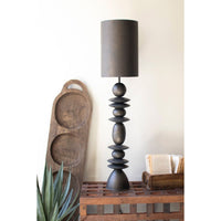Decorative table lamp with a wooden base and dark gray shade in a room setting.