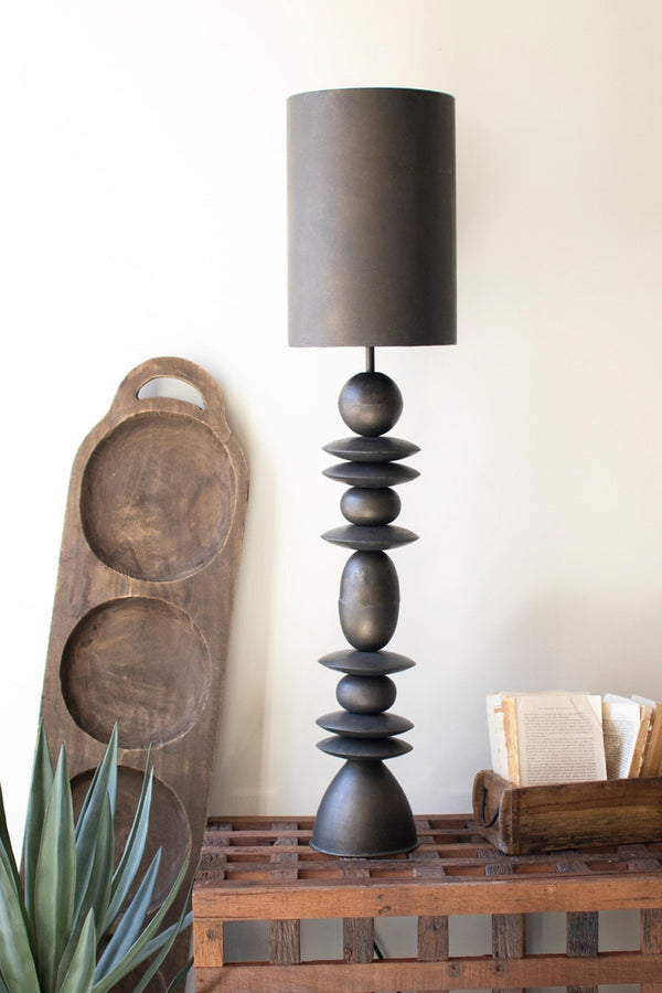 Decorative table lamp with a wooden base and dark gray shade in a room setting.