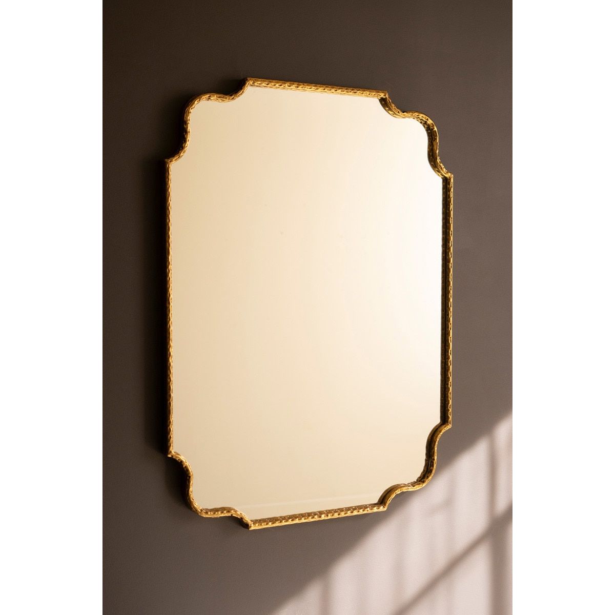 Decorative mirror with gold frame on a dark wall