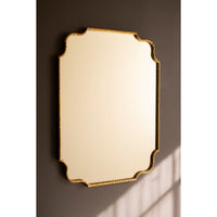 Decorative mirror with gold frame on a dark wall