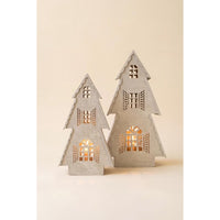 Two small tree-shaped decorative lights with cutout windows and shutters, glowing with warm light from within, set against a plain beige background.