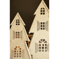 Two miniature beige wooden house ornaments with scalloped edges, cut-out windows, and shutter details, shown against a dark brown background.