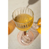 A Kalalou Apple Base Wine Glass from a set of 6 on a table with lemons, casting shadows from the home bar.