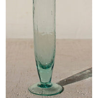 Clear glass vase on a textured surface with a neutral background