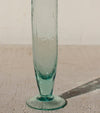 Clear glass vase on a textured surface with a neutral background