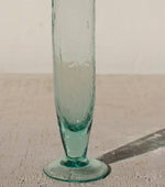 Clear glass vase on a textured surface with a neutral background