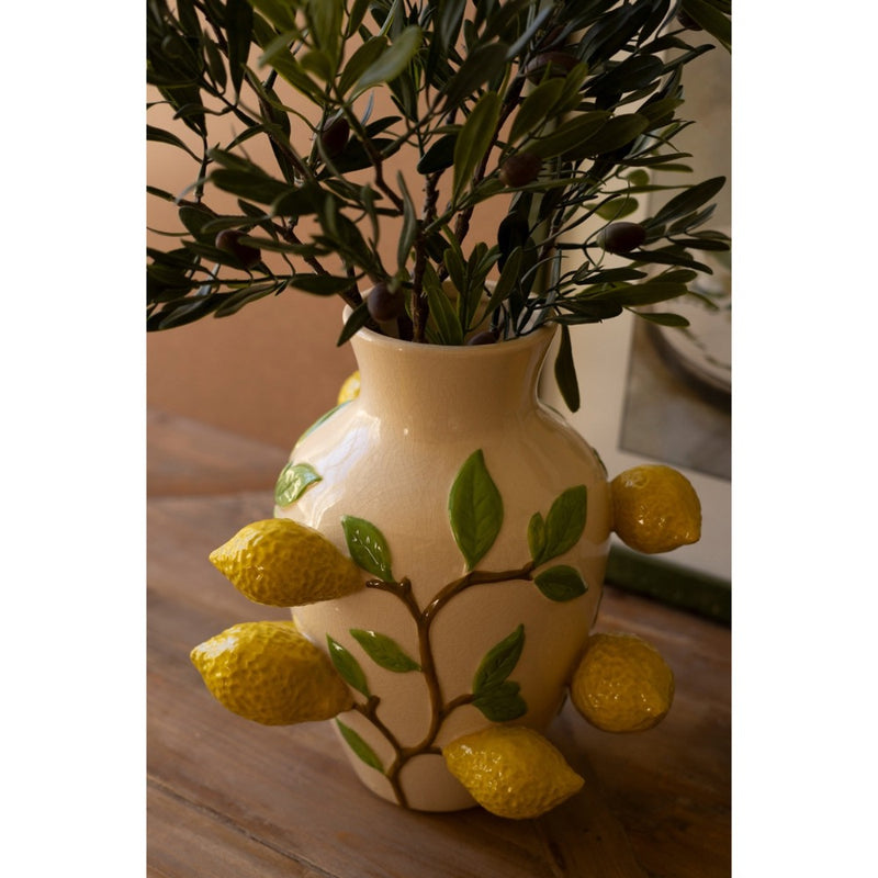 The Kalalou Ceramic Lemons Vase holds branches on a wooden table with its versatile design of lemons and leaves.