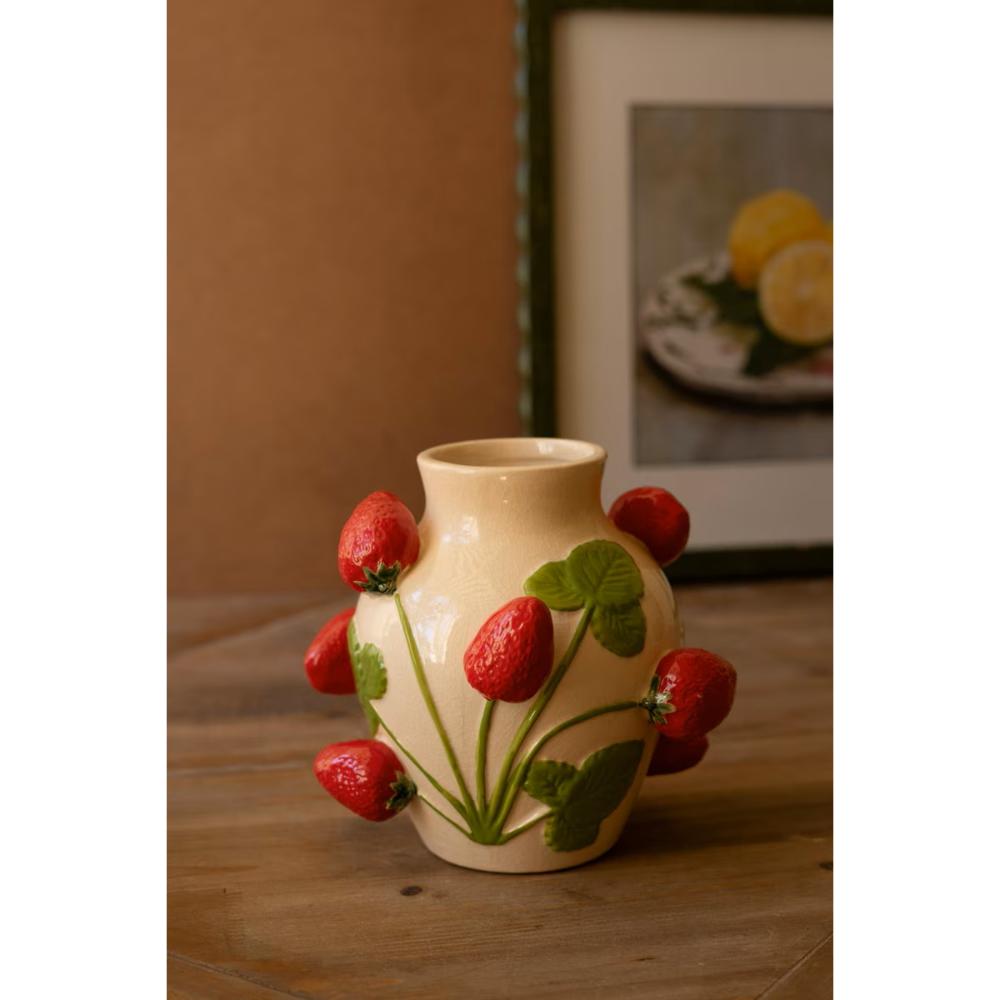 Ceramic vase with strawberry design on a wooden surface