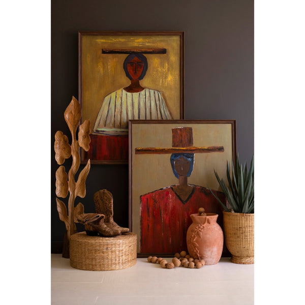 Two framed paintings of stylized figures on a wall with decorative items below.