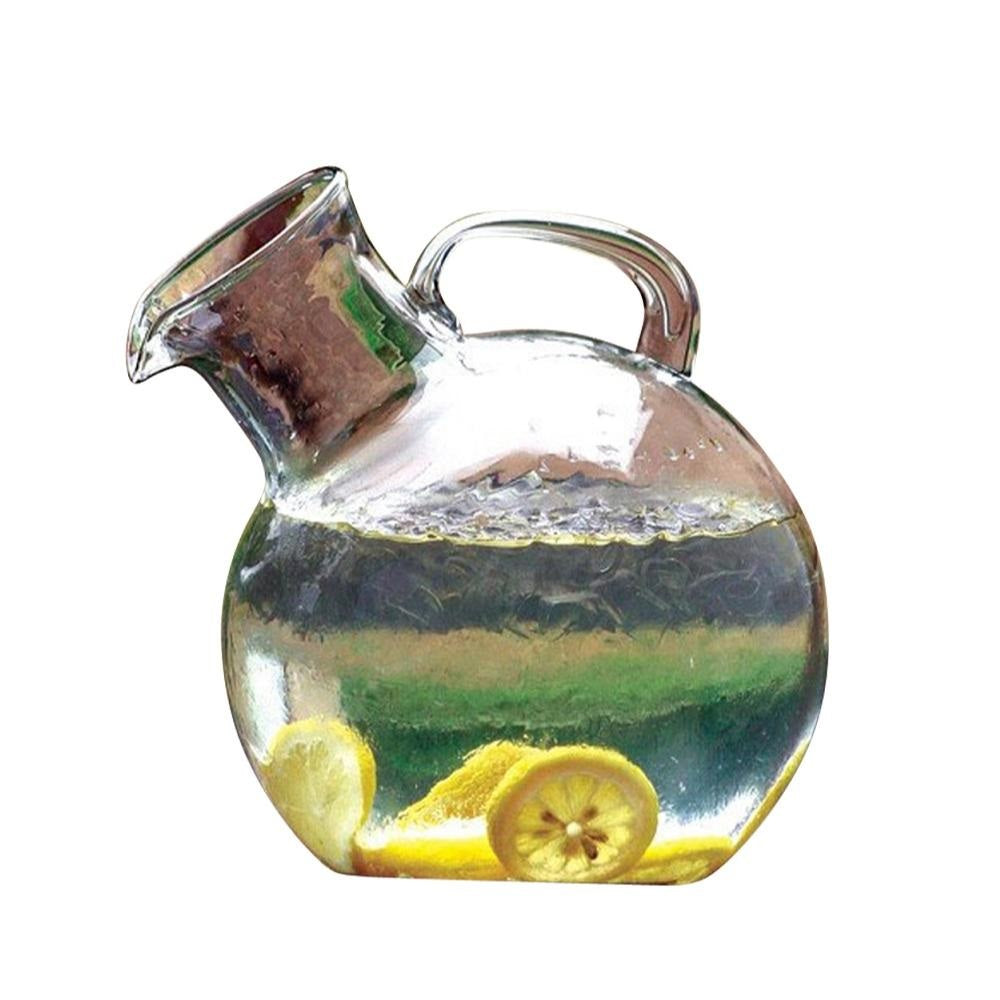 The Kalalou Small Mouthed Circular Tilted Pitcher with handle, filled with water and lemon slices, on white background.