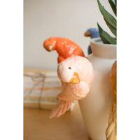 Decorative ceramic bird on a vase with a blurred background