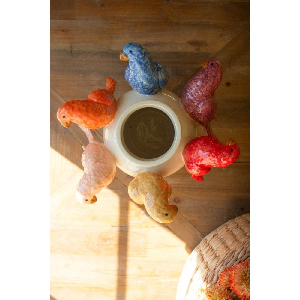 Decorative ceramic birds around a central vase on a wooden surface