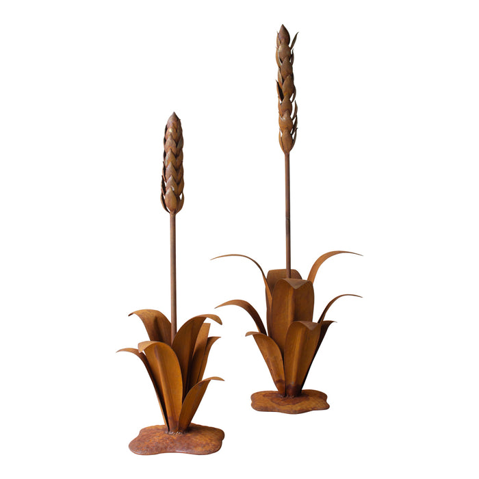 Pair of decorative metal plant sculptures on a white background