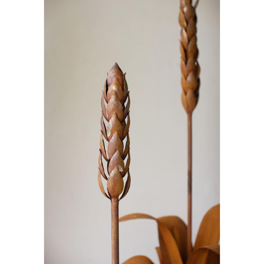 Decorative metal plant stake with braided design against a neutral background