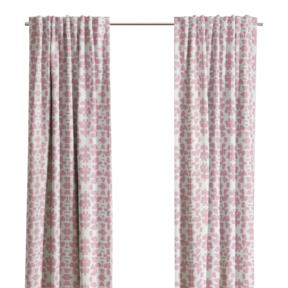 Chintz Rose Curtain Panels by Laura Park Designs, in pink and white, hang before a window with tree views.