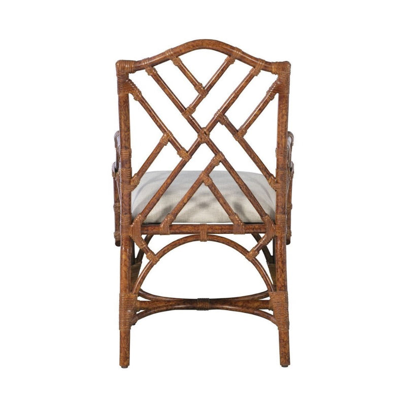Back view of a Kenian Chippendale Arm Dining Chair - Tortoise Finish, featuring a geometric lattice design and a white seat cushion.