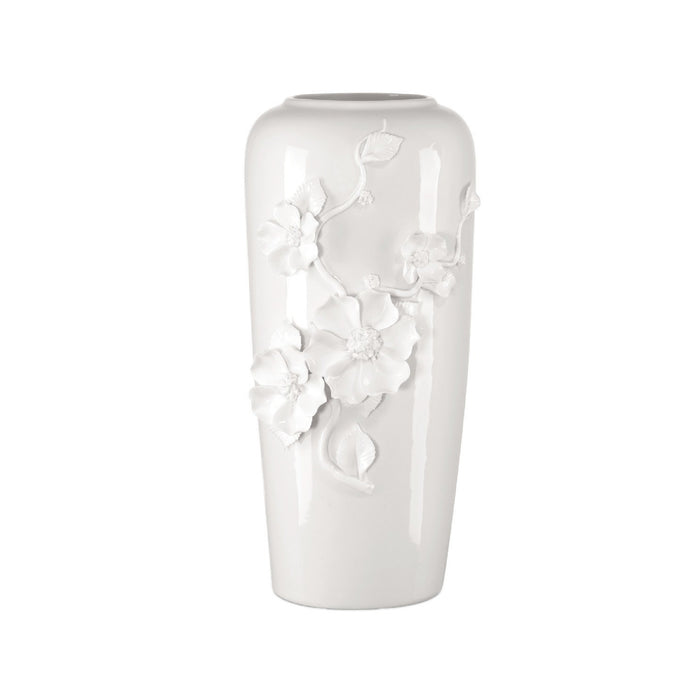 White ceramic vase with floral designs on a white background