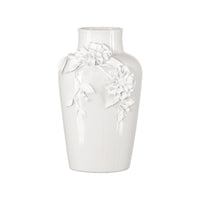 White ceramic vase with floral designs on a white background