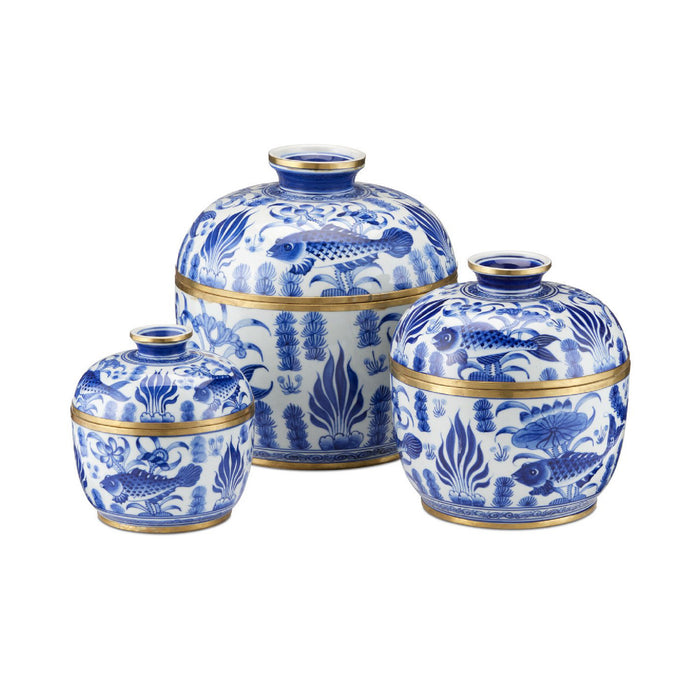Set of three blue and white ceramic jars with fish and leaf patterns on a white background