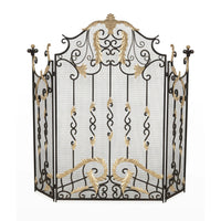 An ornate black wrought iron fire screen with gold-painted leaf and scroll accents, set against a plain white background.