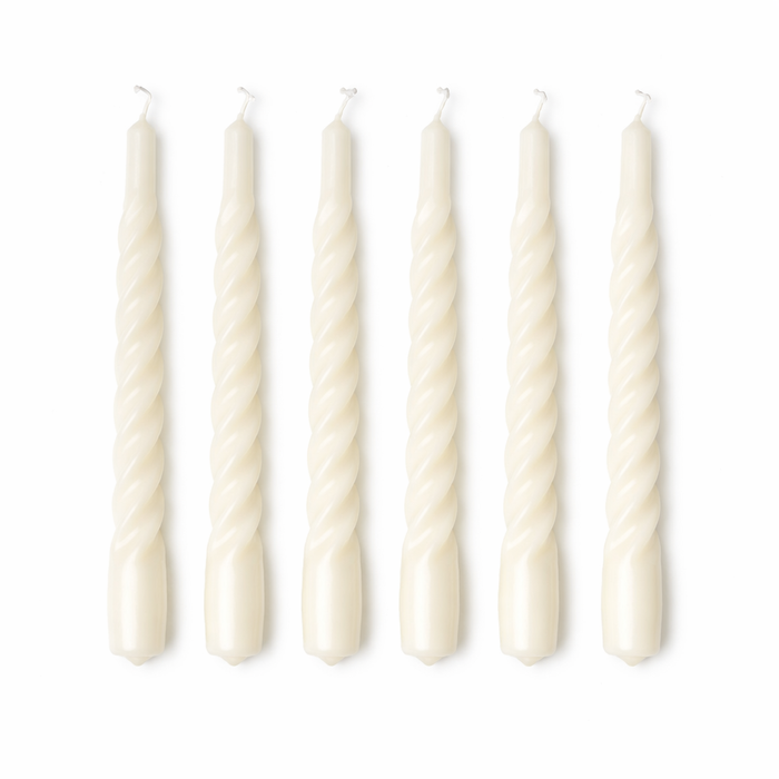 Set of six white twisted candles on a white background