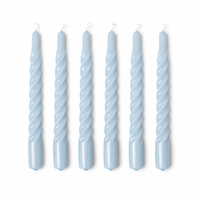 Set of six twisted light blue candles on a white background