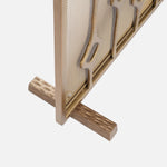 Close-up of the Made Goods Webster Antique Brass Fireplace Screen with a decorative frame and wooden base.
