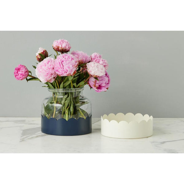 Clear vase with navy scallop base with pink flowers 