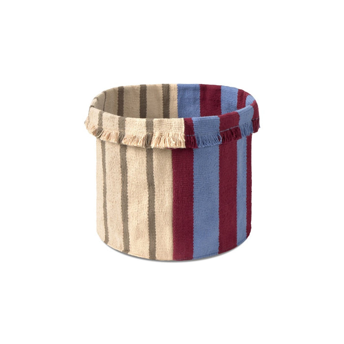 A cylindrical fabric storage basket with a striped pattern in beige, brown, blue, and burgundy, featuring fringed trim on the top edge, shown against a plain white background.